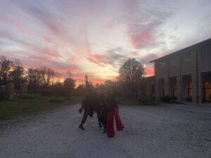 Un gruppo di ragazzi e ragazze con dietro un tramonto