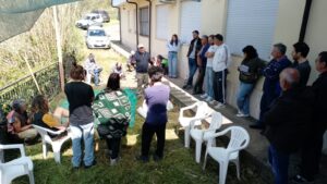 gruppo di persone all'esterno di un'abitazione, in piedi mentre dialogano