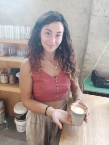 Tifla tippoża b'tazza cappuccino f'idejha