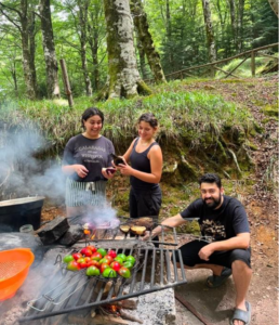 tre persone cucinano alla brace delle verdure